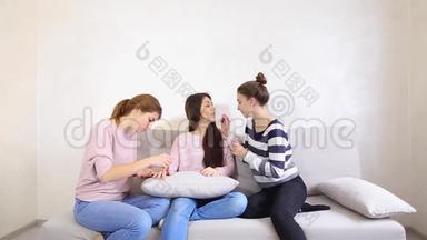 可爱的女朋友在约会时收集女朋友，帮助看起来漂亮，晚上坐在明亮的房间里的沙发上。